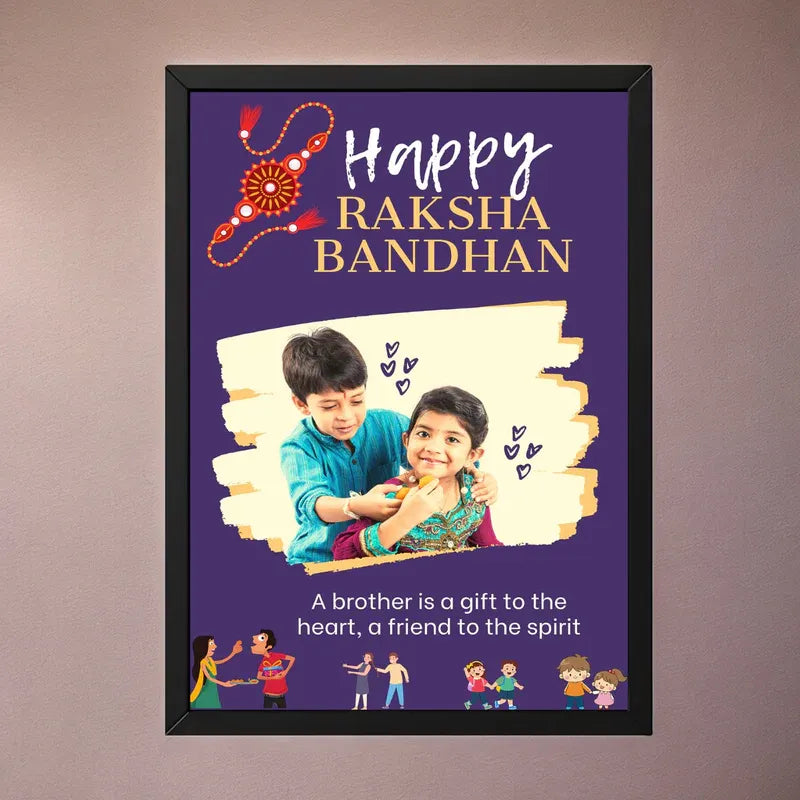 A framed personalized 'Happy Raksha Bandhan' poster with a purple background, gold and white text, a decorative red and orange rakhi, and a photo of two children. The poster is displayed on a neutral brown wall.