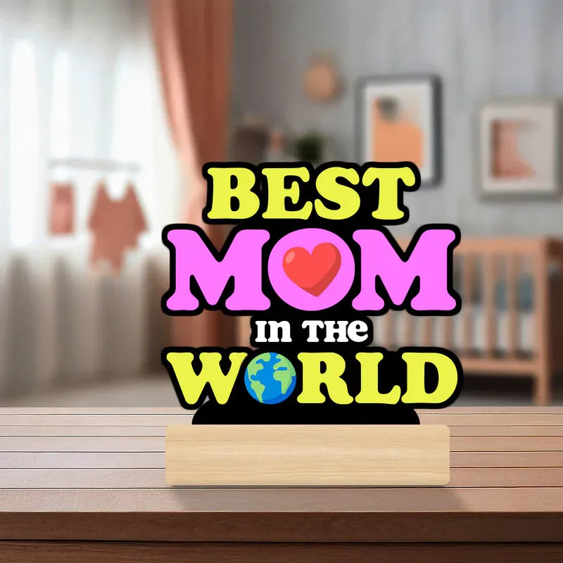 Decorative sign with 'Best Mom in the World' text on a wooden stand in a home setting.