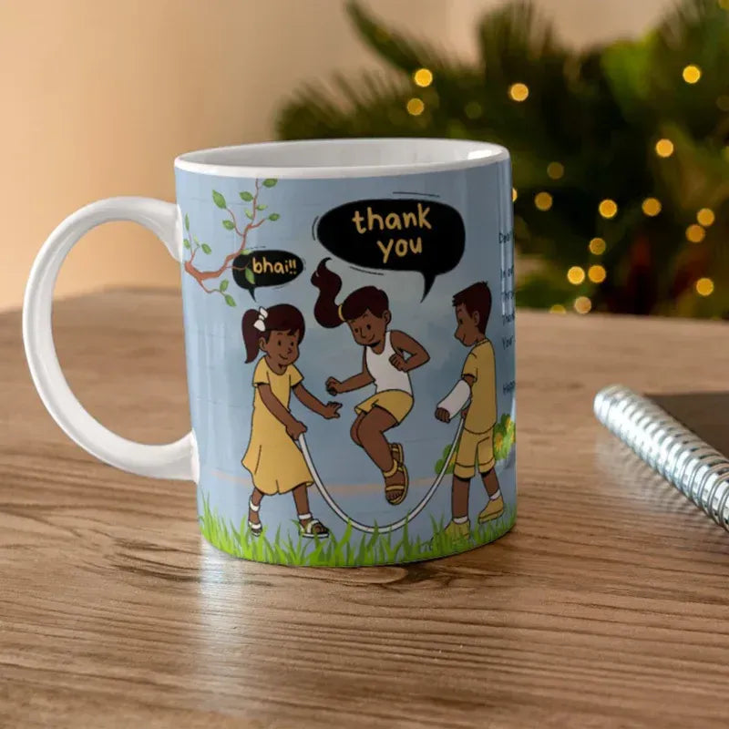 A white ceramic mug with a light blue printed design of three children jumping rope, placed on a wooden table with a blurred festive background.
