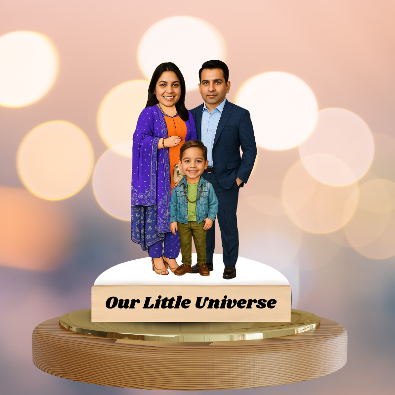Family figurine with 'Our Little Universe' text on a decorative stand against a bokeh light background.