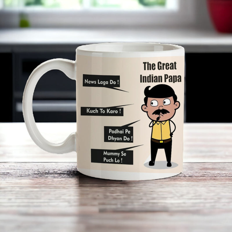 A ceramic mug with text and illustrations related to a Father's Day theme, featuring an illustration of a cartoon character resembling a father and text phrases such as 'THE GREAT INDIAN PAPA' and 'MUMMY SAID PUCH LO'.