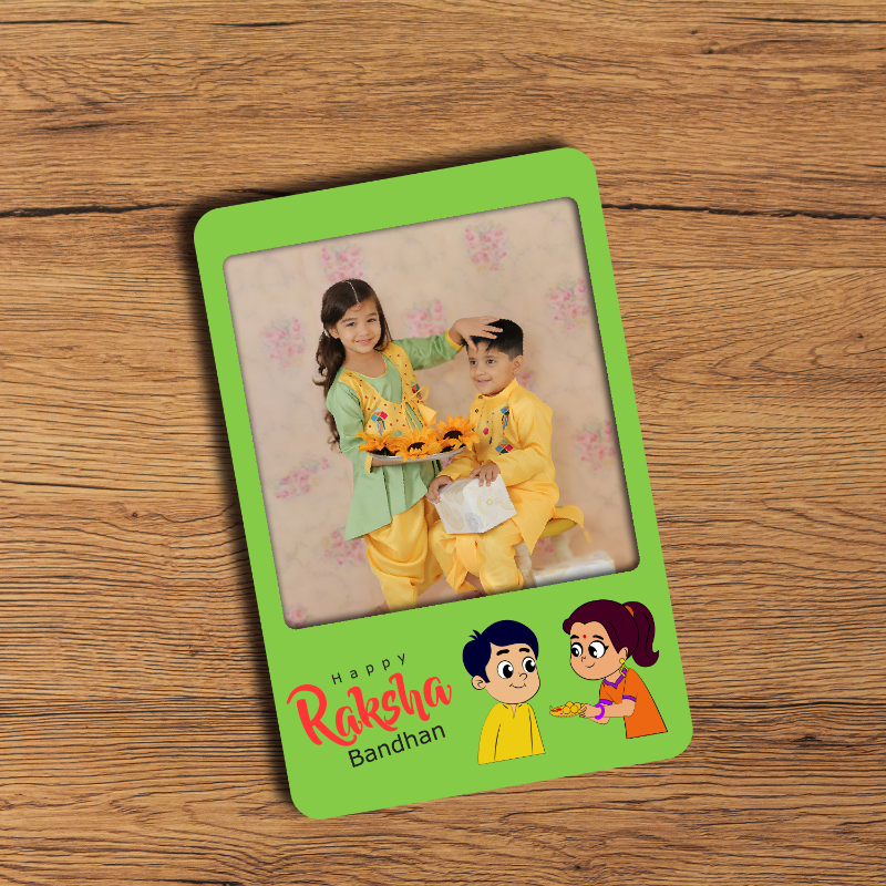 A personalized Rakhi bandhan fridge magnet featuring a photo of two children and a cartoon illustration of a sister placing a Rakhi on a brother's wrist, with Hindi text on the magnet.