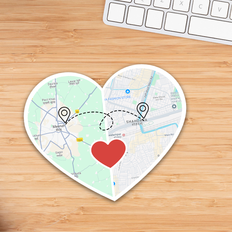 Heart-shaped map with a red heart in the center on a wooden surface with a keyboard.