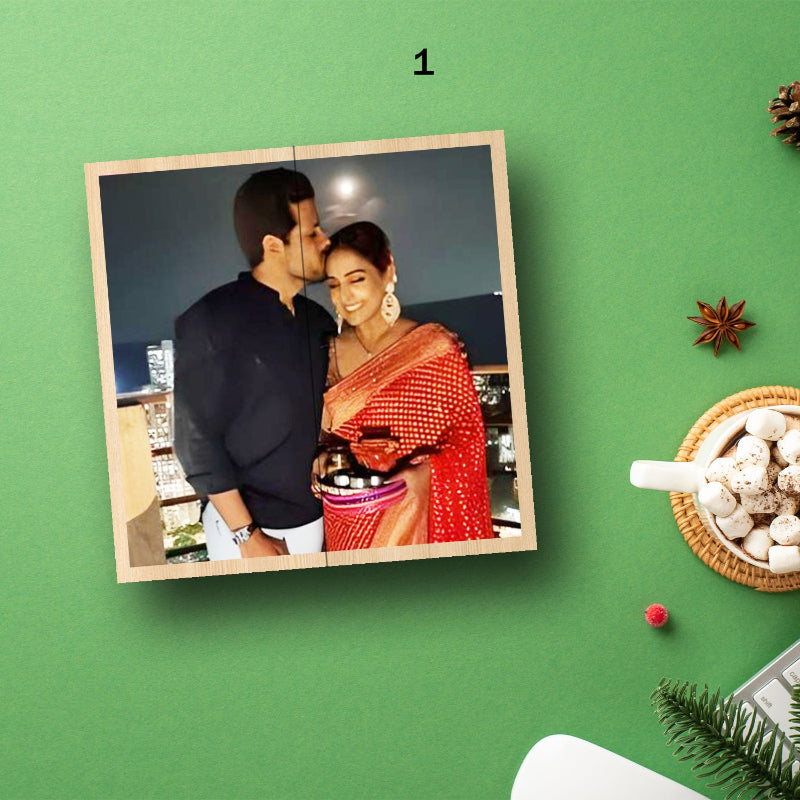 A photo rolling cube with an image of a couple on one of its sides, displayed on a green surface surrounded by festive decorations.