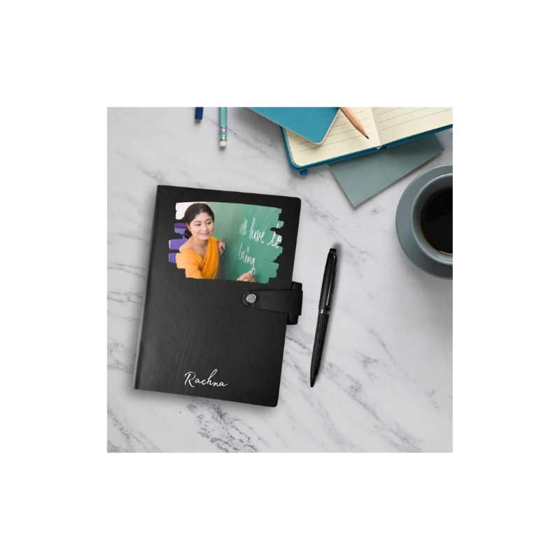 Black notebook with a photo cover on a marble surface with stationery items.