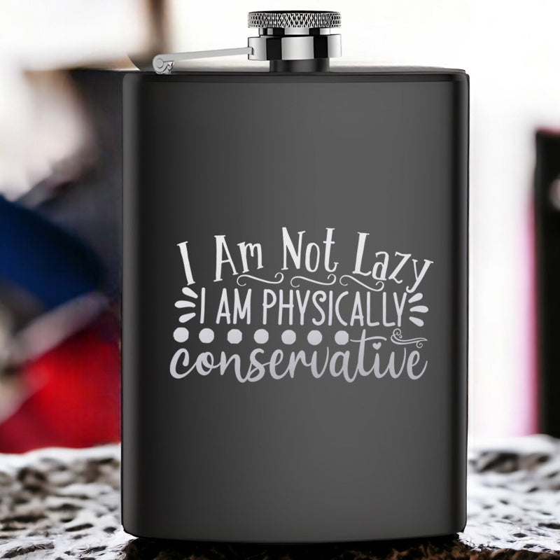 A stainless steel hip flask with an engraved text 'I Am Not Lazy, I Am Physically Conservative'.