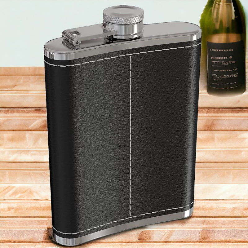 Black leather flask with silver accents on a wooden surface