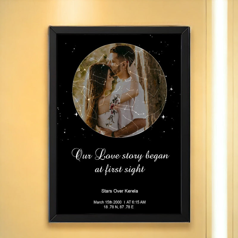A framed couple's star map with a black border, displaying an image of a couple looking at a star map, with the text 'Our love story began at first sight - Star Over Kerala' along with a date and time.