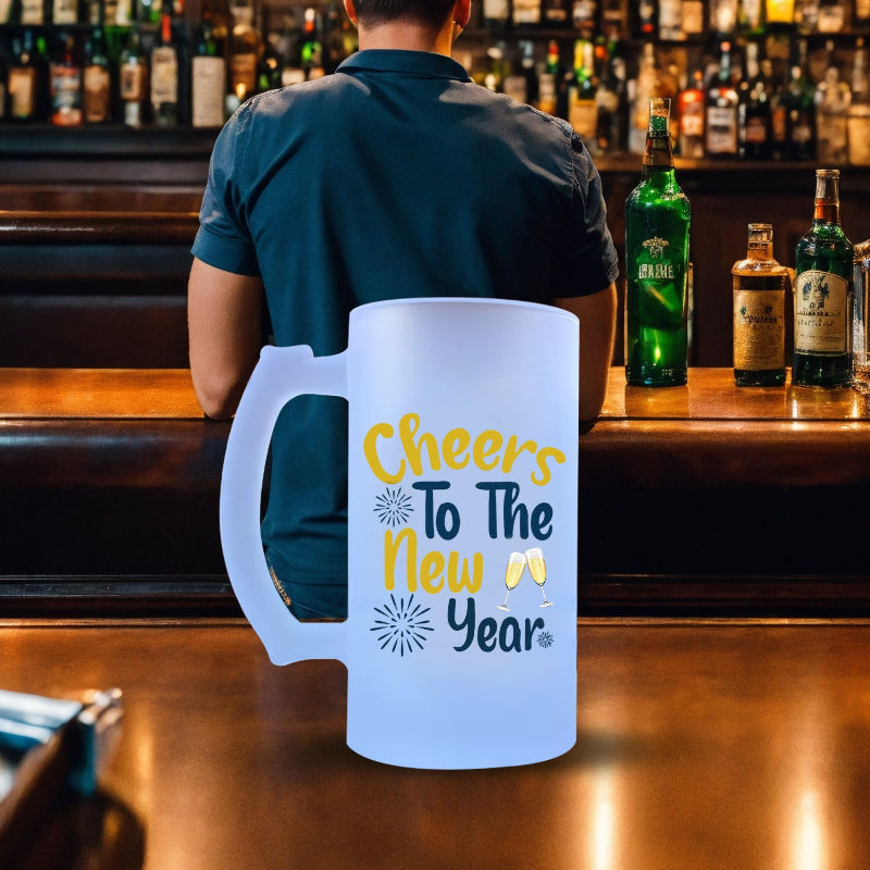 Large white mug with 'Cheers To The New Year' text on a bar counter with bottles in the background.