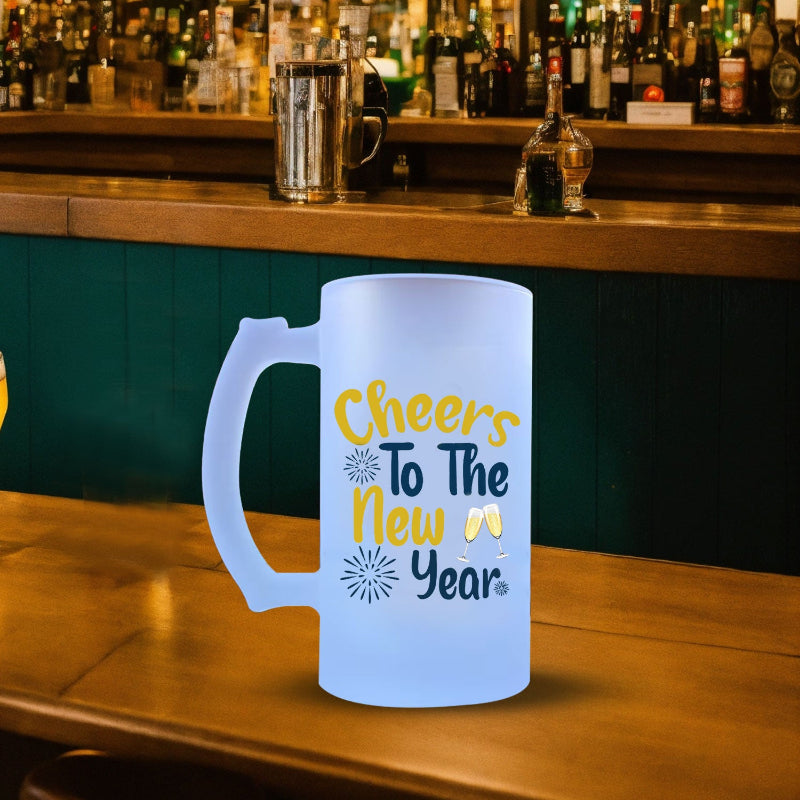 A blue beer mug with 'Cheers to the NEW YEAR' printed in yellow, placed on a wooden table in a bar setting.