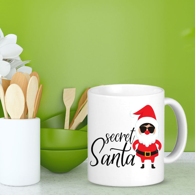 White mug with 'secret Santa' design on a green background