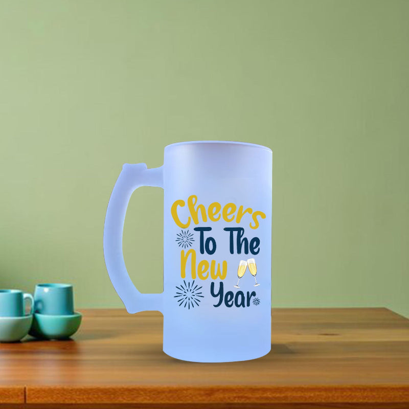 Frosted mug with 'Cheers To The New Year' text on a wooden table with green background