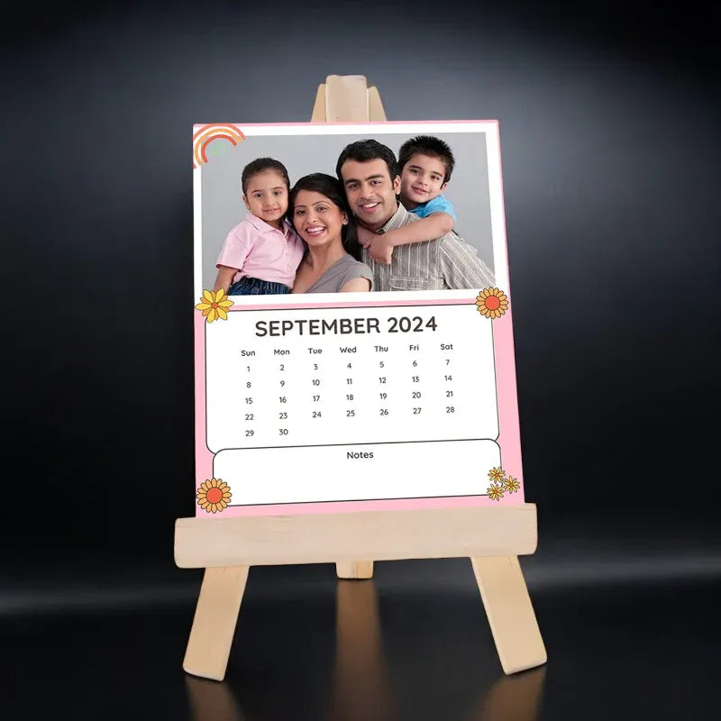 Calendar with a family photo on a wooden easel against a dark background