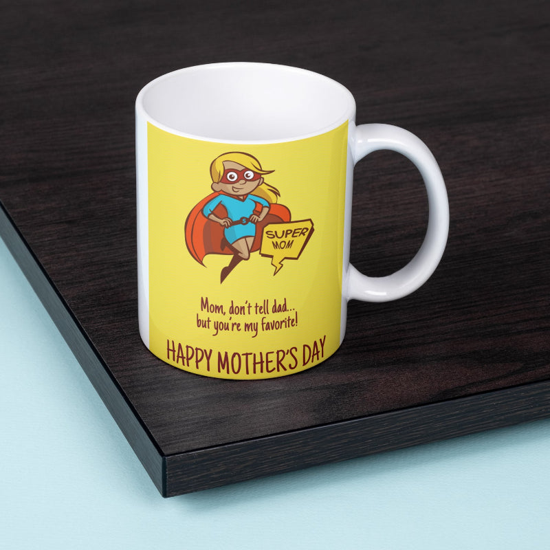 Mug with a superhero-themed design for Mother's Day on a wooden surface.