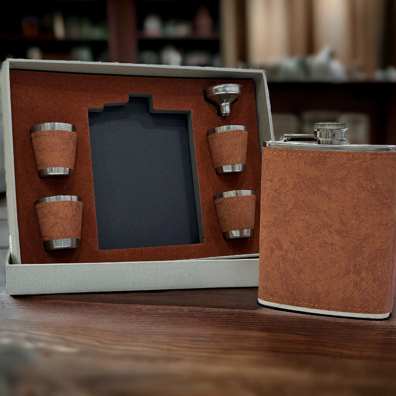 Brown leather flask set with four cups on a wooden surface
