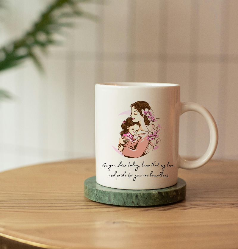 Mug with a design of a woman holding a child and text on a wooden surface.