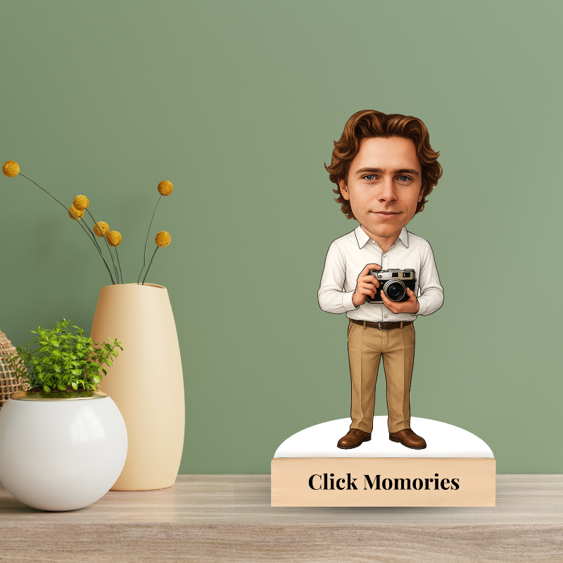 Bobblehead of a man holding a camera with 'Click Memories' branding on a green background