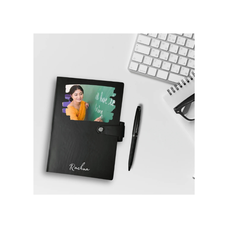 Black notebook with a photo cover on a desk with a keyboard and pen