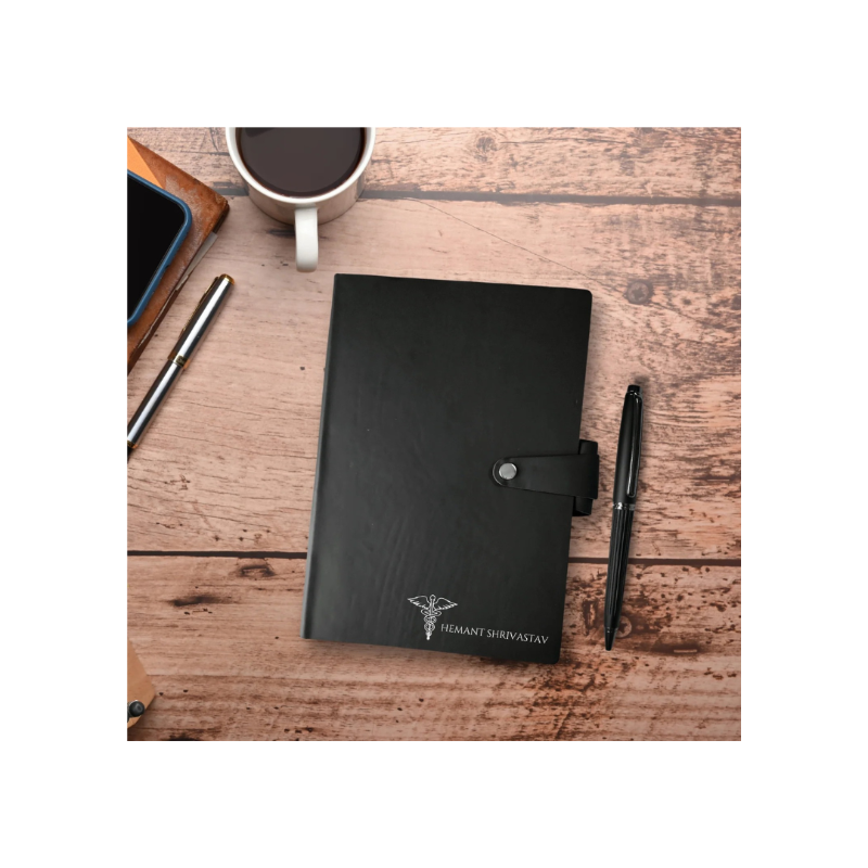 Black notebook with a pen and coffee cup on a wooden surface