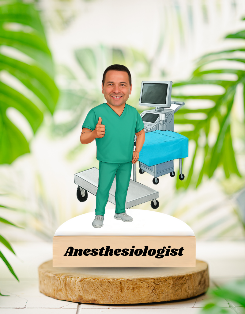 Bobblehead figure of an anesthesiologist with a medical cart and computer in the background, on a wooden base with 'Anesthesiologist' text.