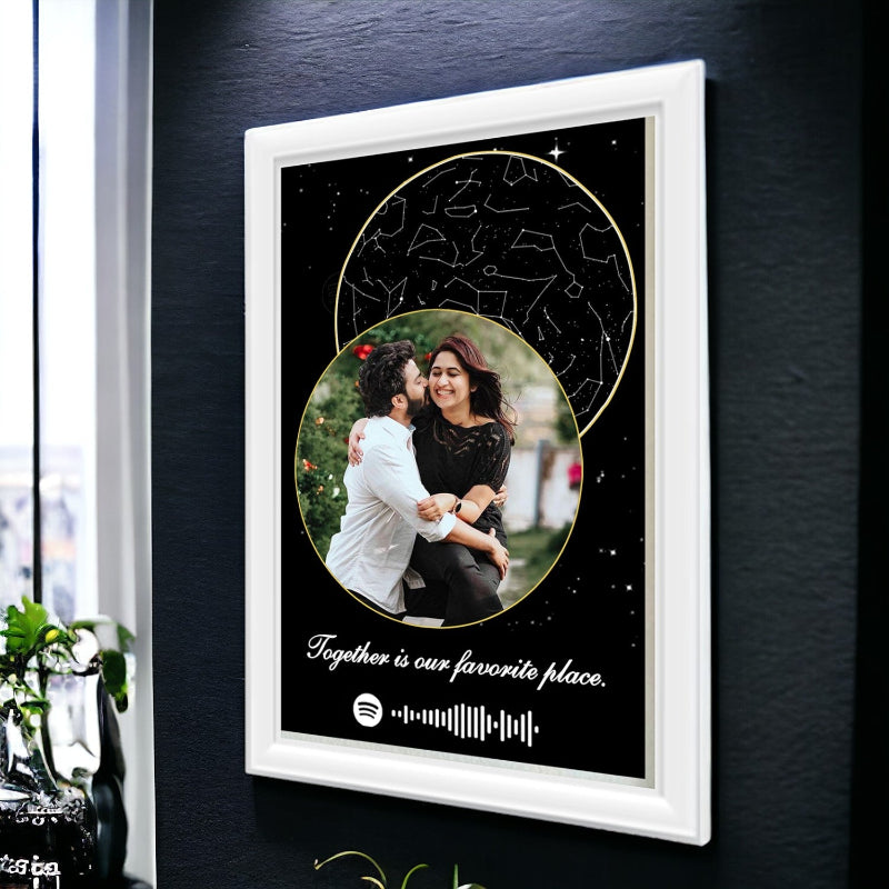 Framed artwork with a couple's photo and celestial design on a dark wall.