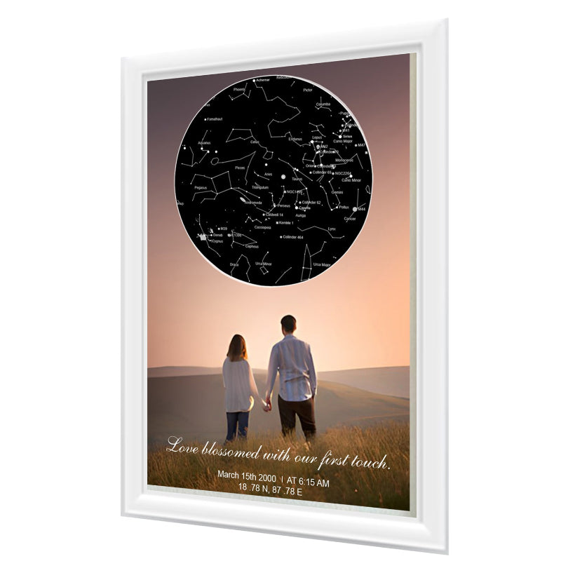 Framed artwork of a couple holding hands with a star map above them, set against a sunset sky.
