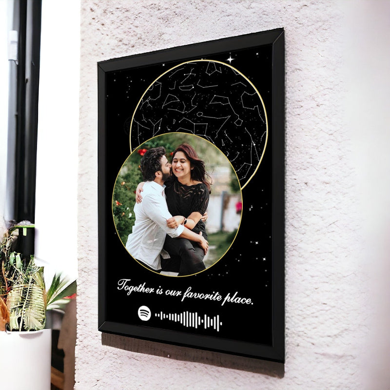 Framed artwork with a couple's photo and constellation design on a textured wall.