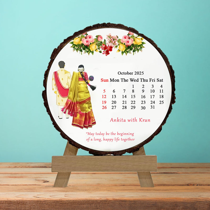 Circular calendar with floral design and people in traditional attire on a wooden stand against a light blue background.