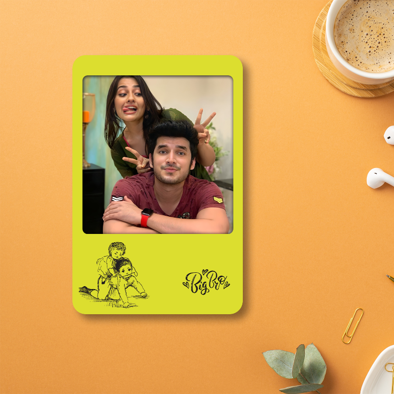 Green photo frame with a couple's picture on an orange surface with a cup of coffee and earphones.