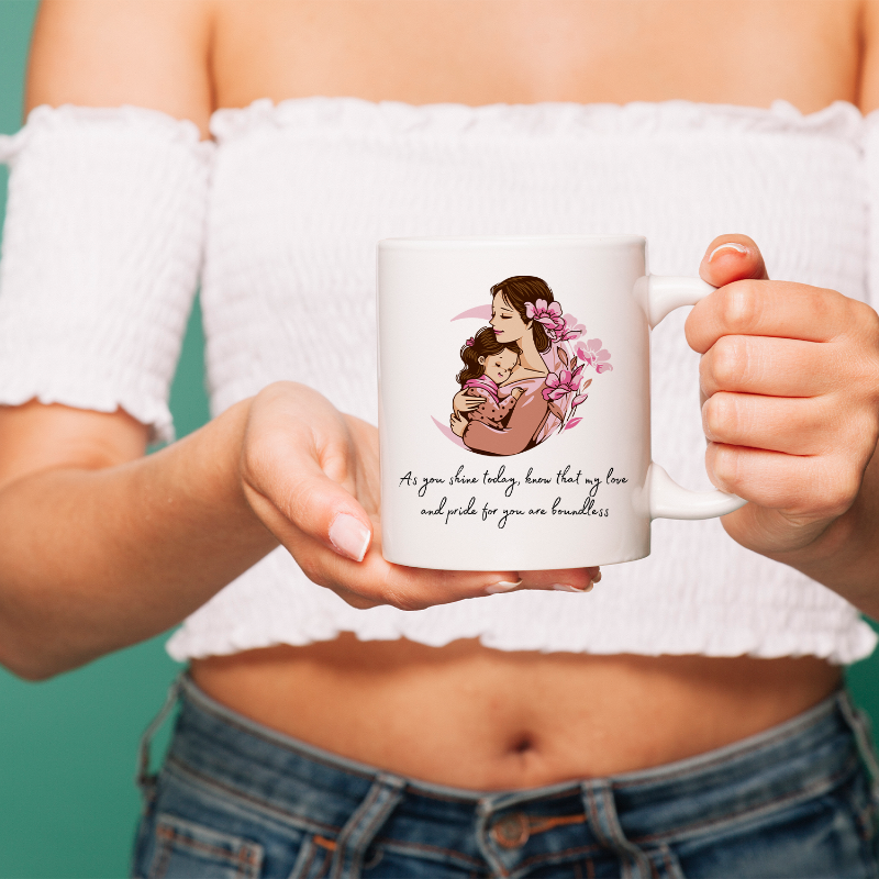 Person holding a mug with a design of a woman holding a child and flowers, set against a teal background.