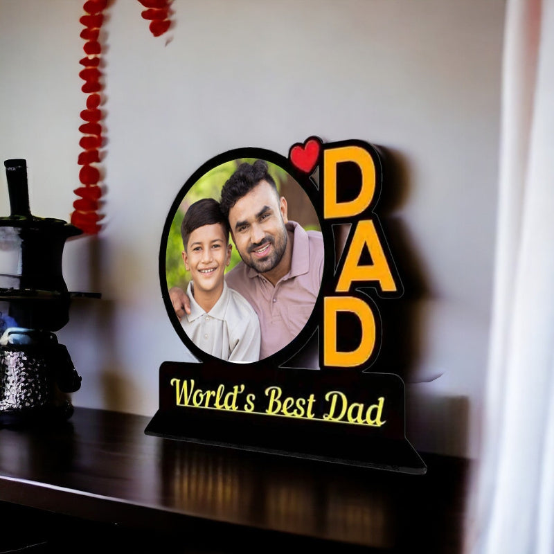 Personalized photo plaque with 'DAD' and 'World's Best Dad' text on a table.