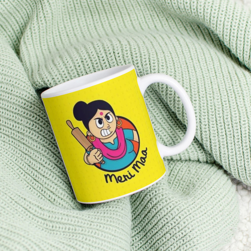 Yellow mug with cartoon character and 'Meri Maa' text on a green textured background
