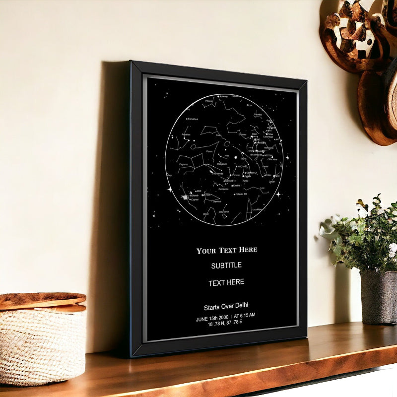 Framed star map with customizable text on a wooden shelf.