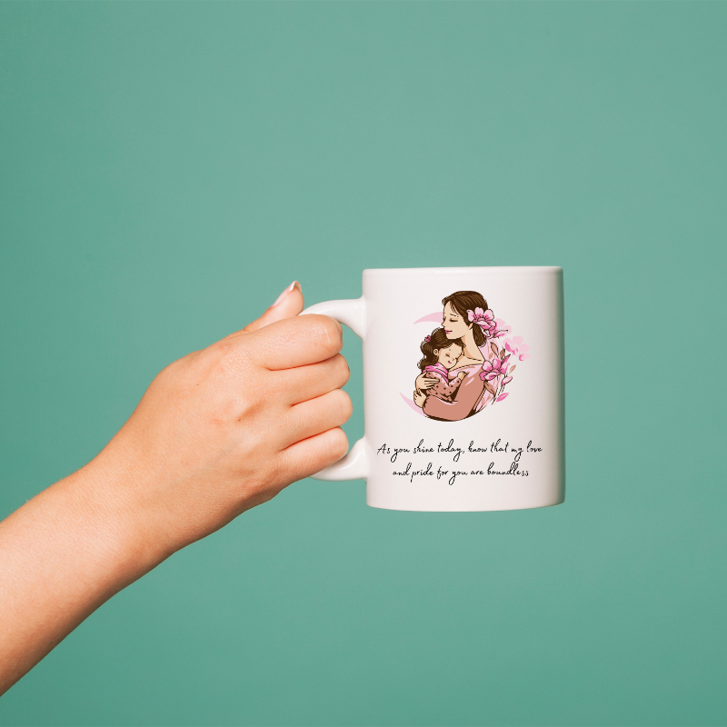 Hand holding a mug with a mother and child illustration and text on a teal background