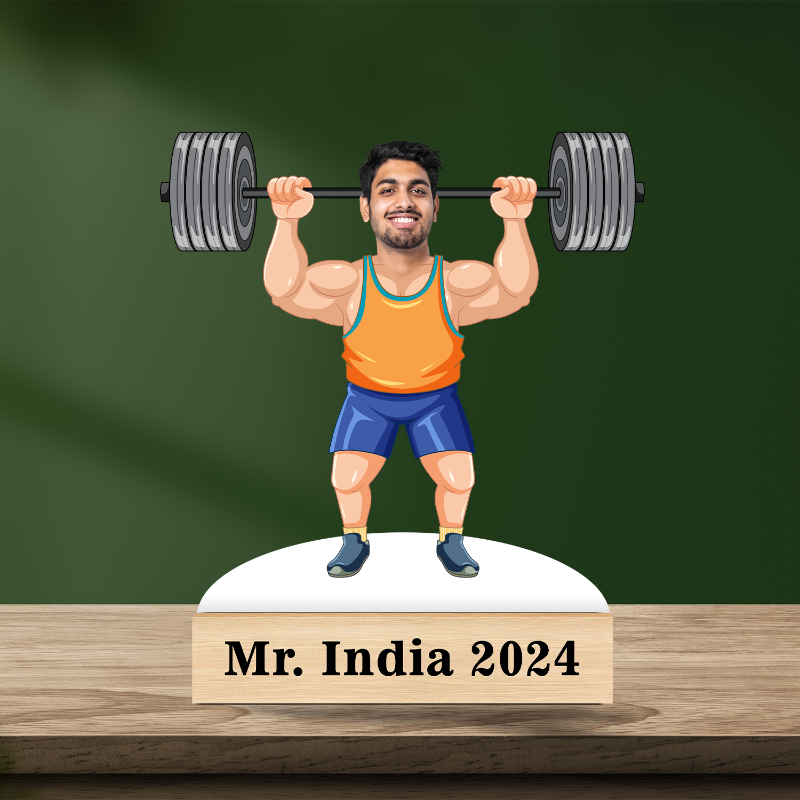 A 3D caricature of a male figure with muscular build, wearing a tank top and blue shorts, holding a pair of dumbbells, and standing on a pedestal with a label 'Mr. India 2044'.