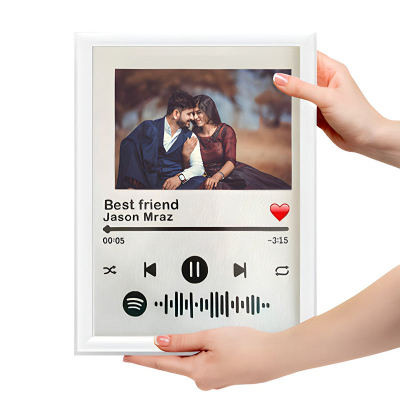 Framed photo of a couple with music player design, held by hands.
