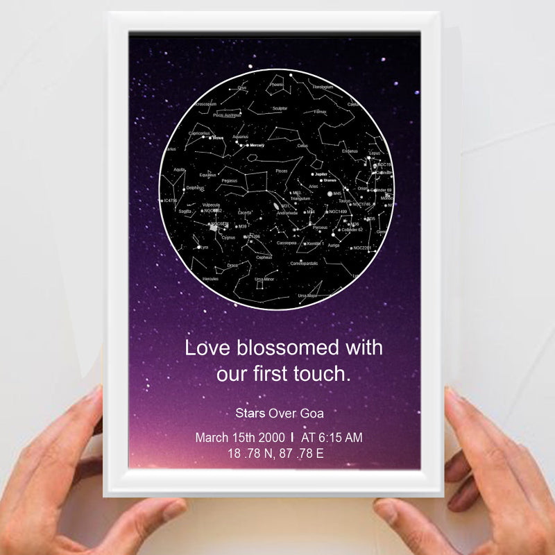 Framed star map with personalized text held by hands against a white background