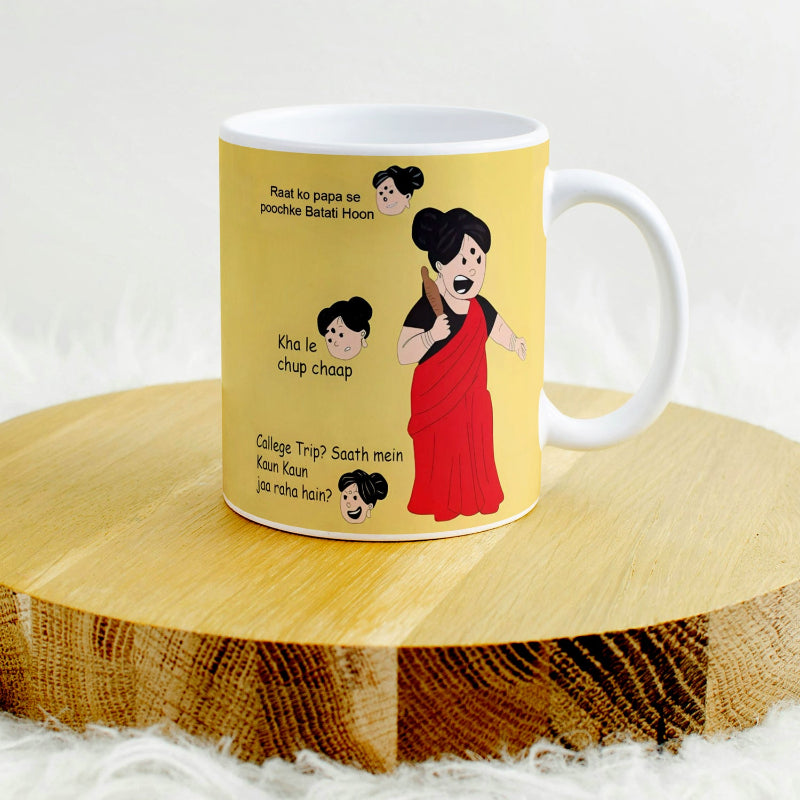 A ceramic mug with printed text and cartoon images, displayed on a wooden surface.