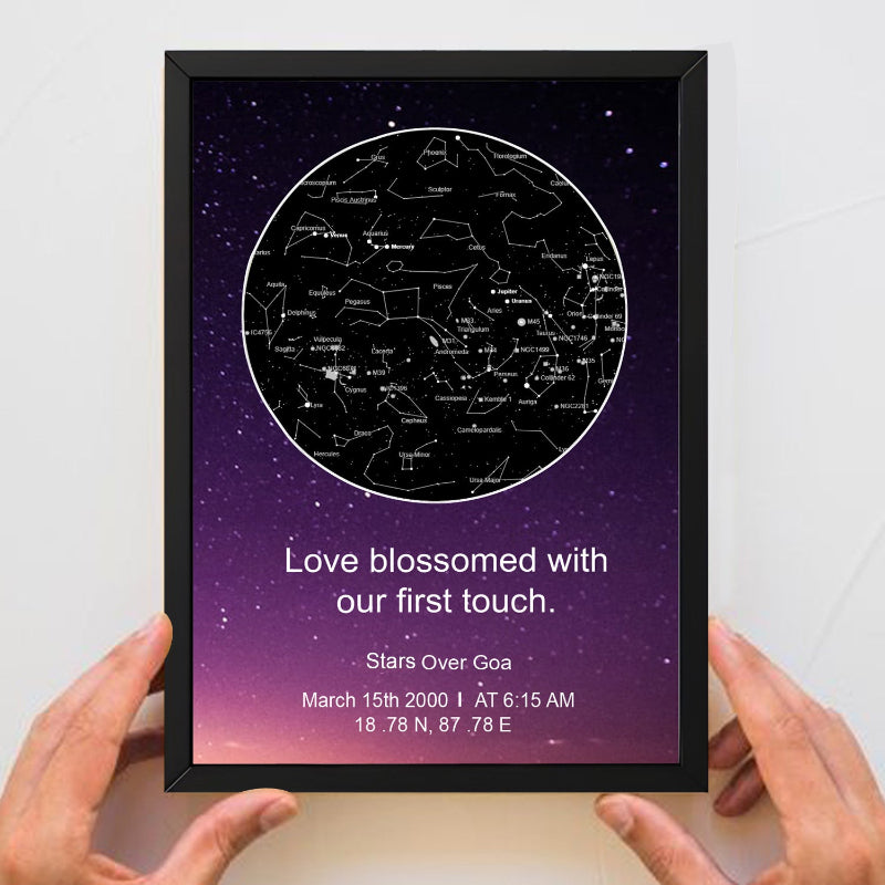Framed star map with personalized message held by hands against a white background