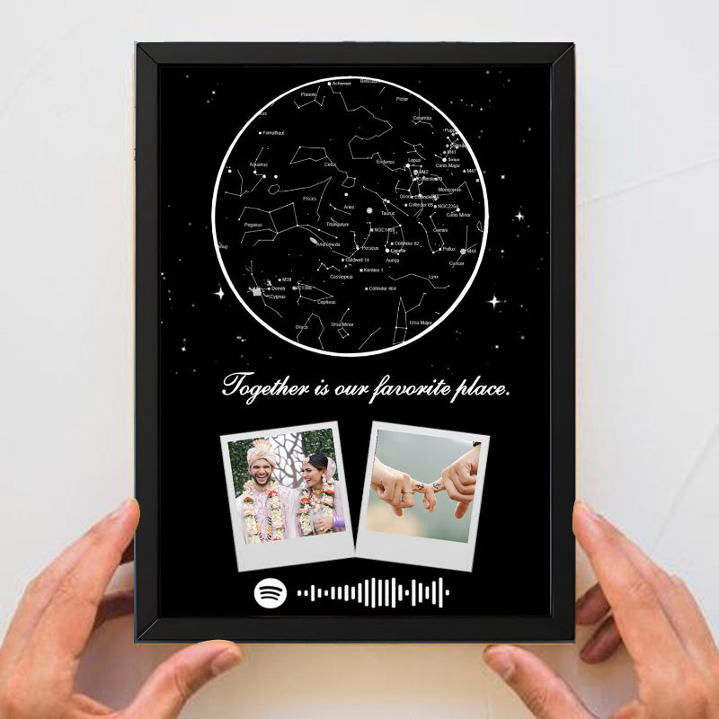 Framed artwork with star map and two polaroid-style photos, held by hands against a white background.