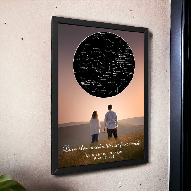Framed artwork of a couple holding hands with a star map above them on a wall.