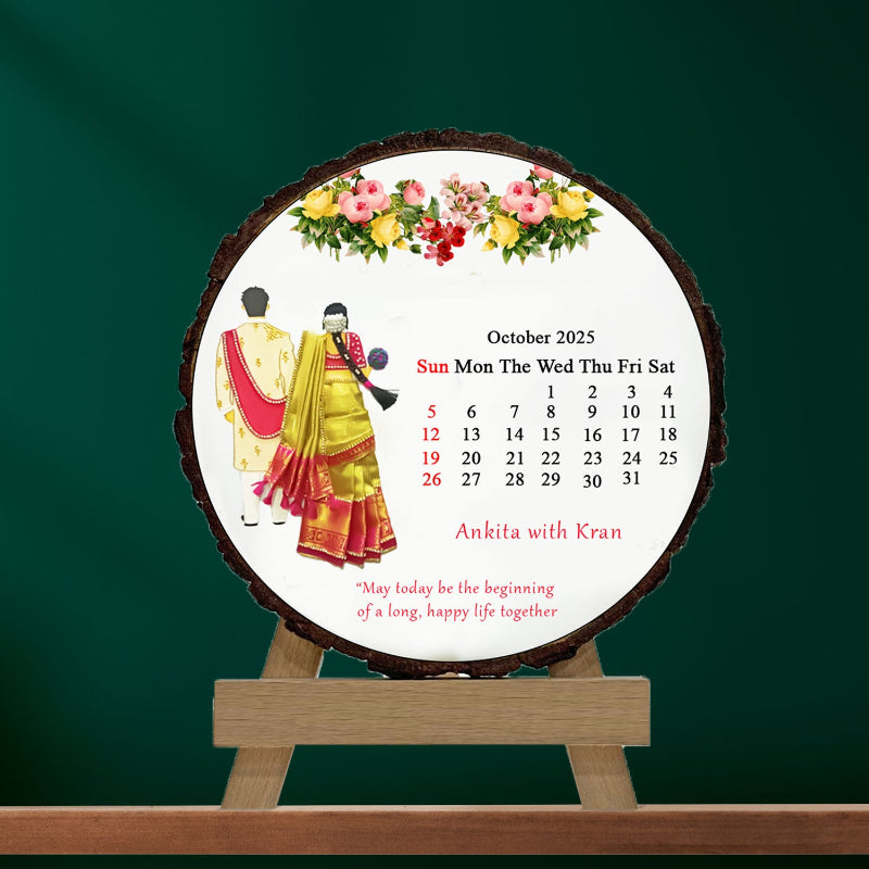 A personalized wooden slice photo frame with a couple's photo, a calendar month chart, and floral decorations on a green background.