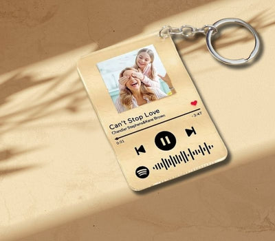 Custom Spotify keychain with music player design and photo of a couple on a beige background