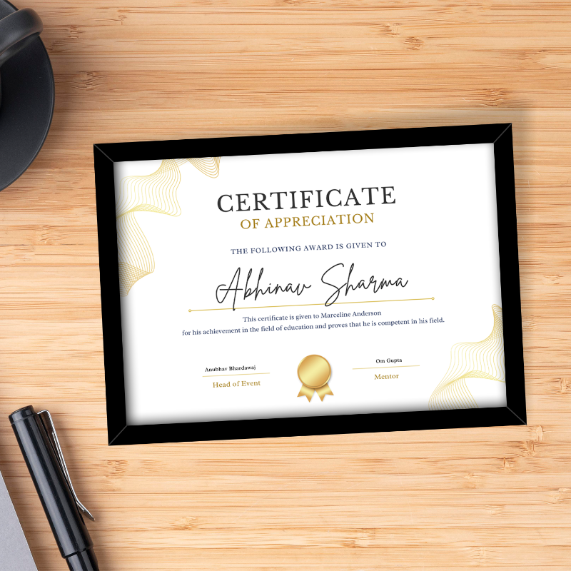 Framed certificate of appreciation on a wooden surface with a pen and hat.