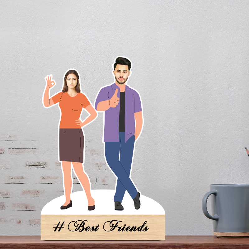Cardboard cutout of a man and woman on a stand with '# Best Friends' text, placed on a wooden surface.