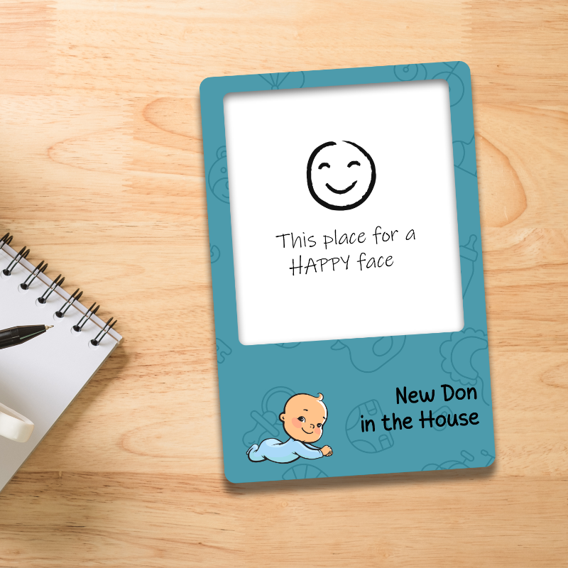 Baby milestone card with smiley face and text on a wooden surface