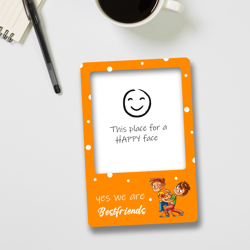 Small orange frame with cartoon characters and text on a white surface with a coffee cup and pen.