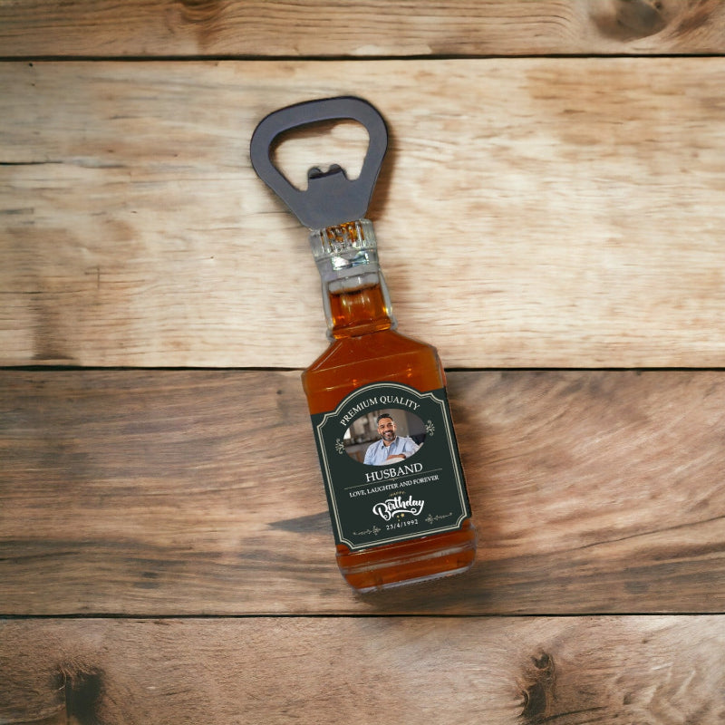 A personalized wooden bottle opener with a metal ring, engraved with a message and a photo, presented on a wooden surface.