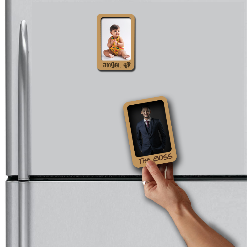 Hand placing a wooden photo frame magnet on a refrigerator with another magnet displaying 'The Boss'.