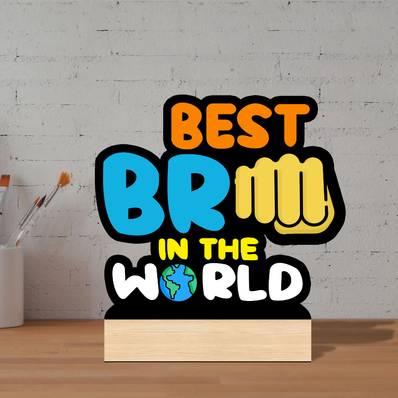 Decorative sign with colorful text 'BEST BRM IN THE WORLD' on a wooden stand against a gray brick wall.